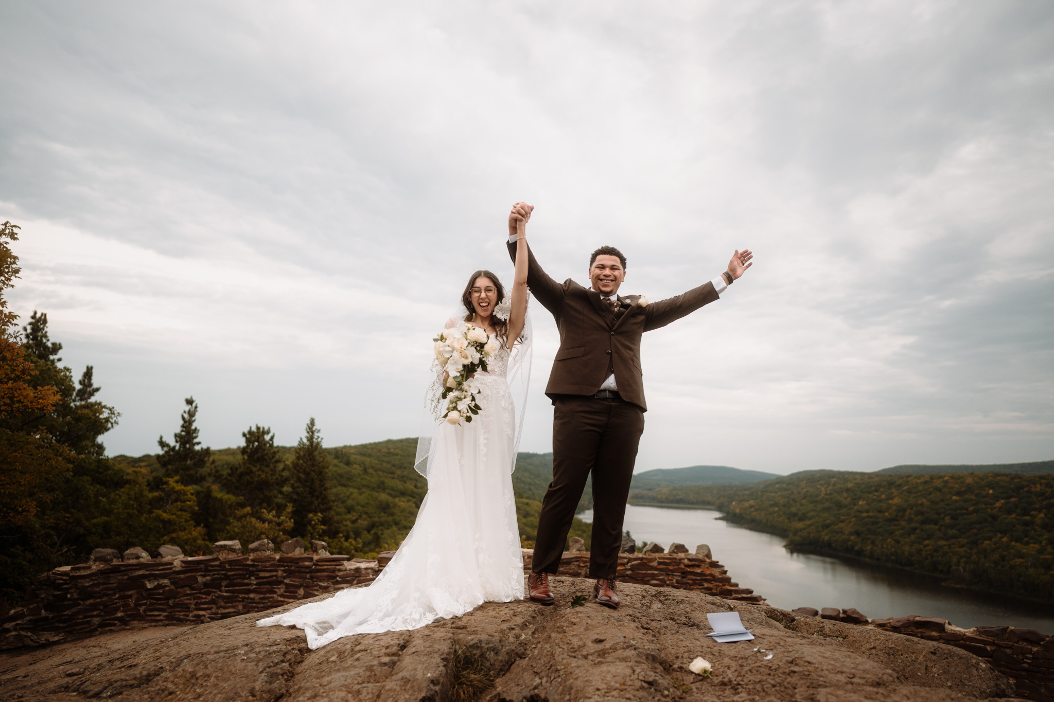 Couple celebrating after eloping at Lake of the Clouds in the Porcupine Mountains, Michigan